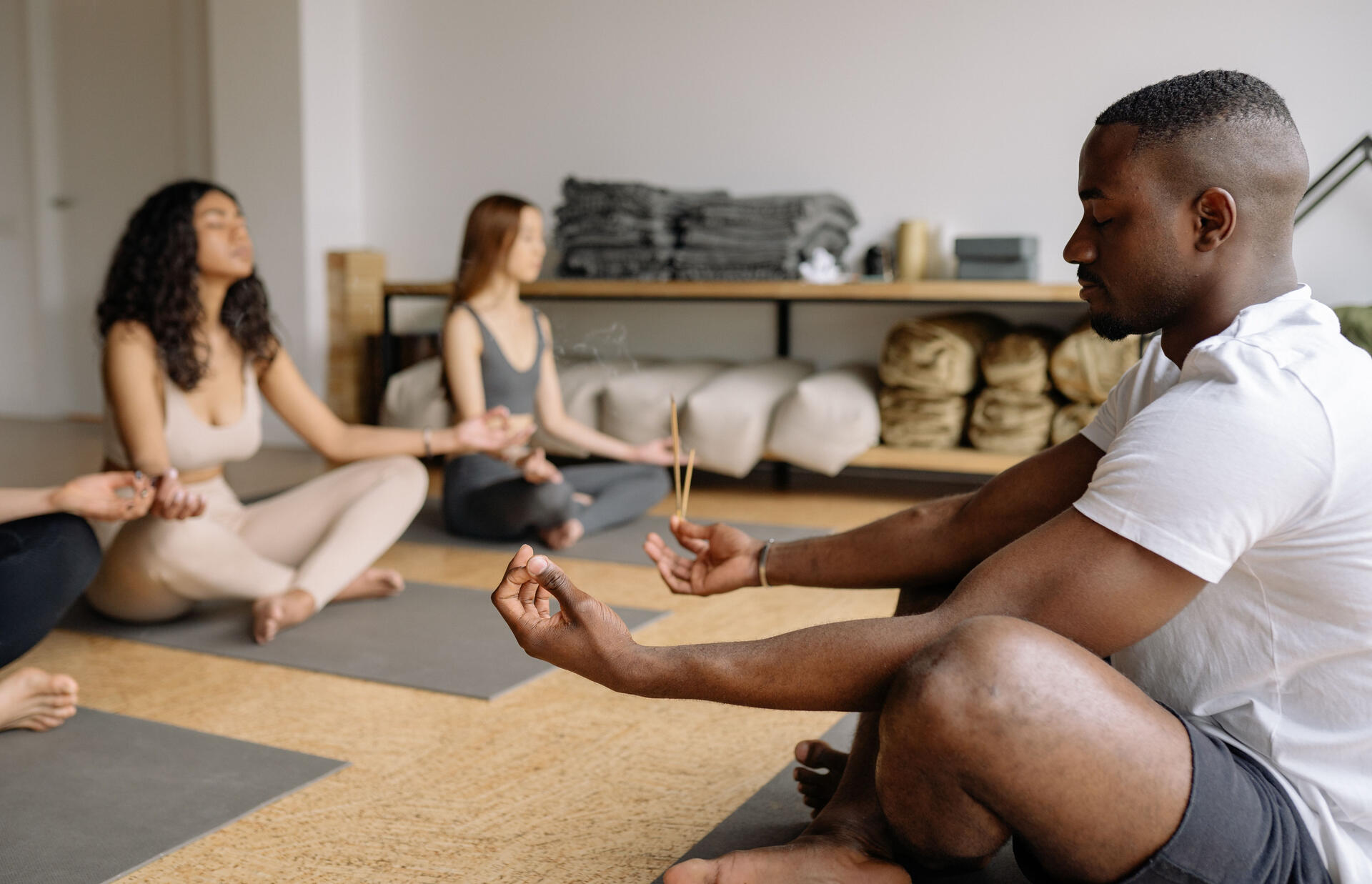 Meditation class Man meditating in front of a class of women meditating