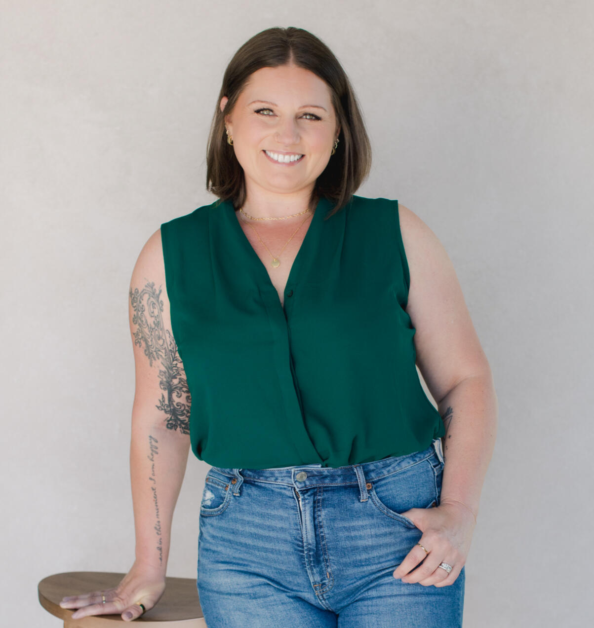 Ashley Fry headshot Woman with short brown hair and a green sleeveless shirt smiling